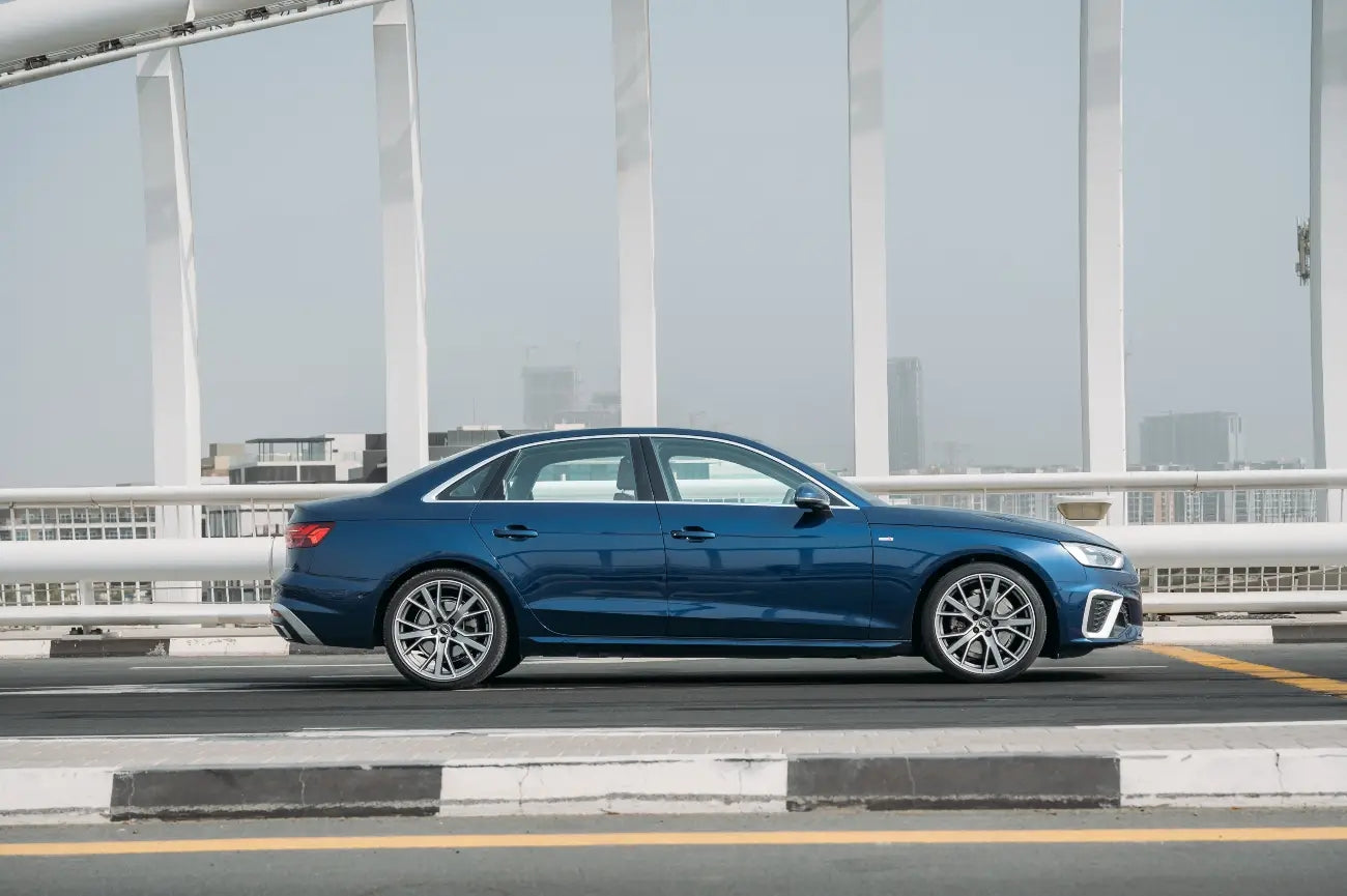 Audi A4 with open sunroof parked overlooking Dubai skyline, ideal for luxury drives.
