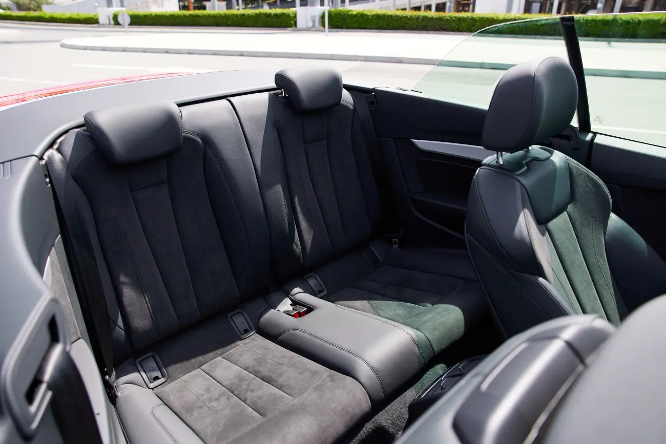 Audi A5 Cabrio with the top down, parked by the Dubai coastline, epitomizing luxury convertible rental.