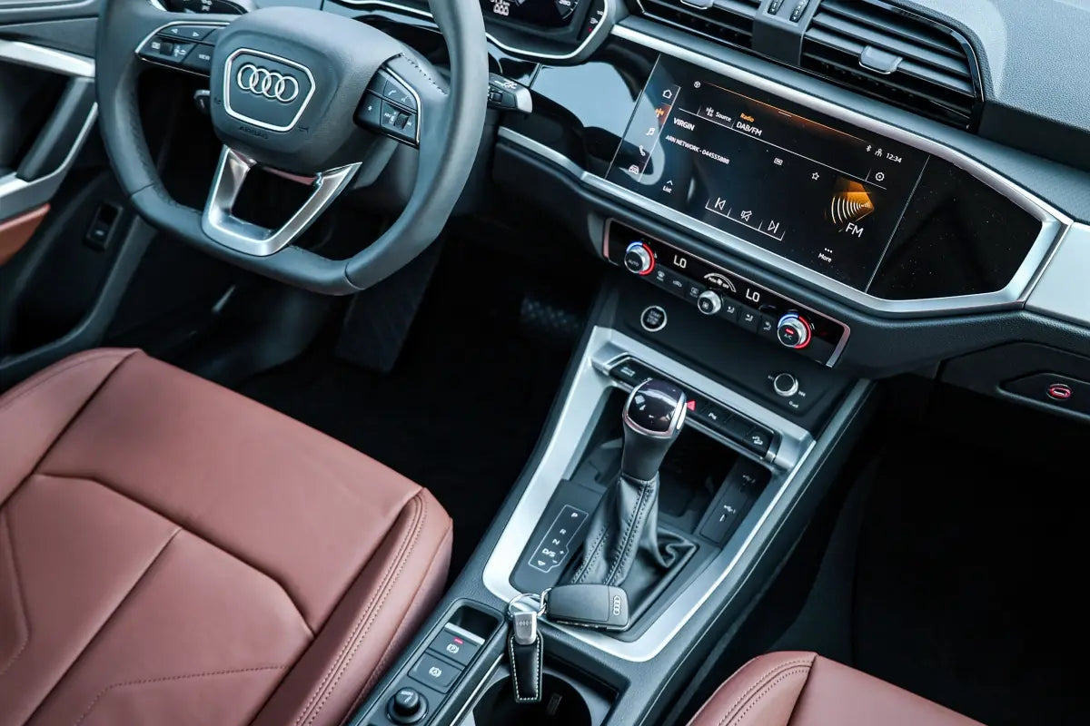 Audi Q3 dashboard and steering wheel, epitomizing luxury for rent in Dubai's competitive car market.