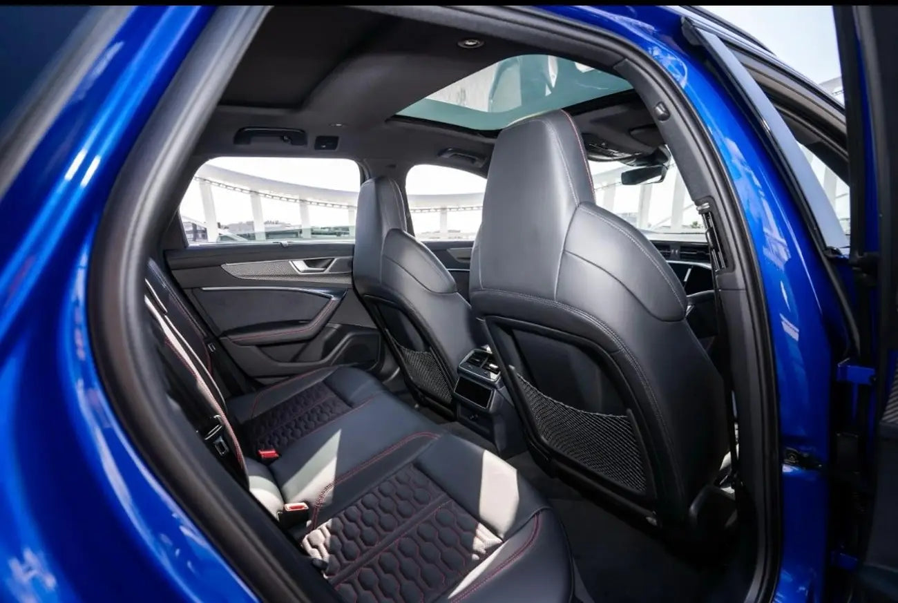 Night view of Audi RS6 Avant under Dubai's city lights, epitomizing luxury car rental elegance.