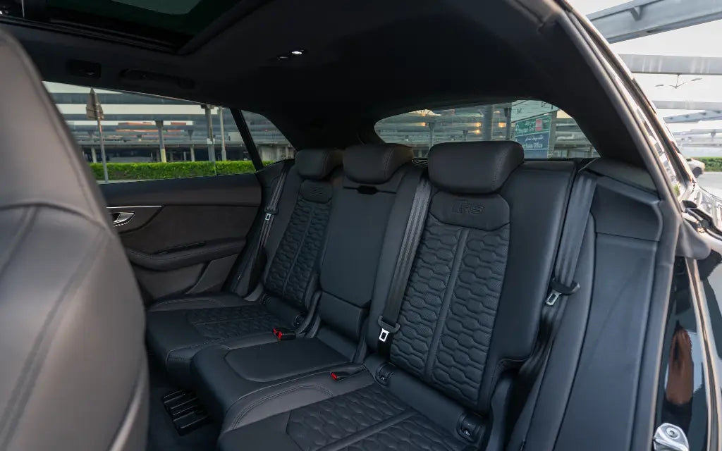 Audi RSQ8 cruising on a scenic Dubai highway at sunset, showcasing its elegance and power for rent.