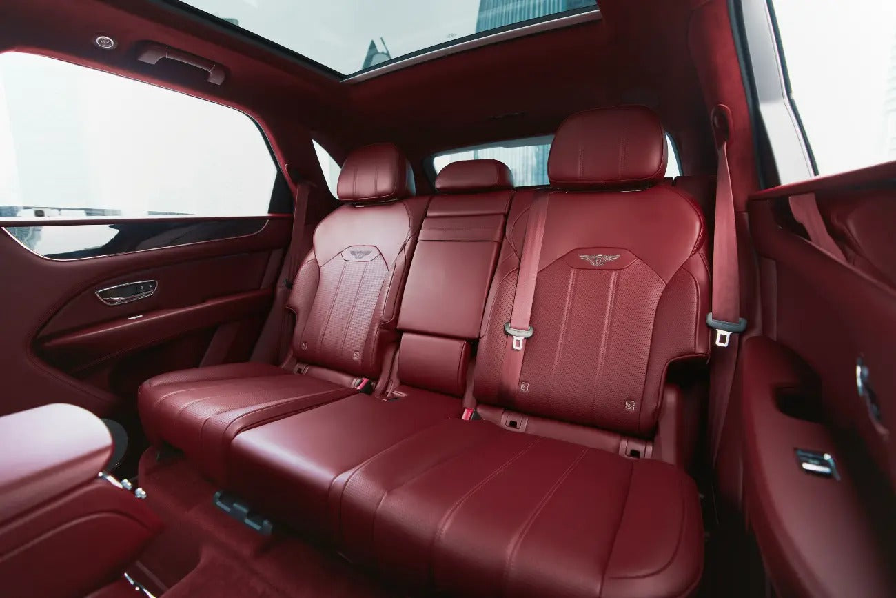 Bird's eye view of a Bentley Bentayga navigating through Dubai's landscape, showcasing its elegant design.