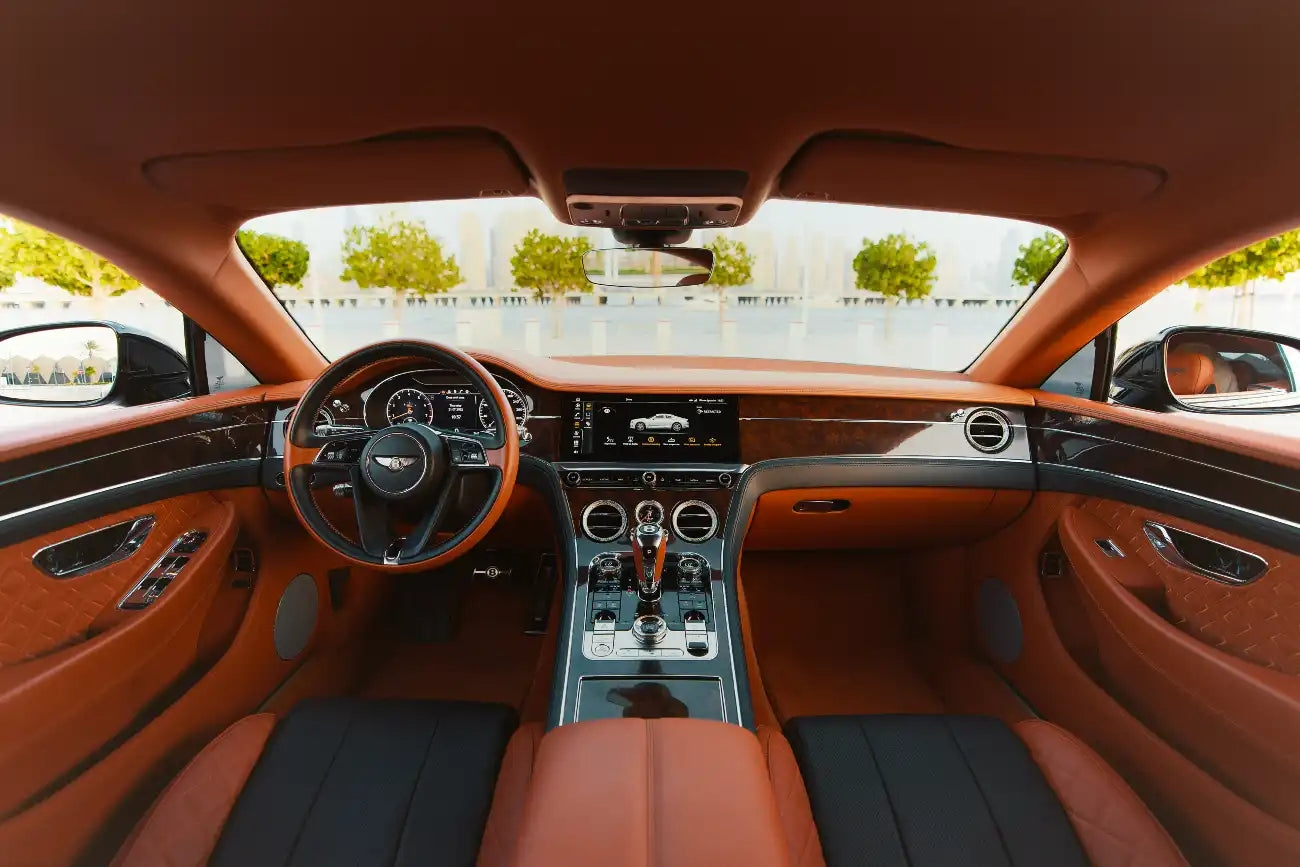 Bentley Continental GT cruising on Dubai's roads, showcasing its sleek design and powerful performance for luxury rentals.