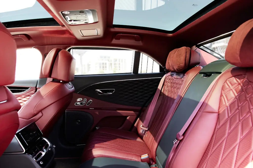 Night view of a Bentley Flying Spur under city lights, a top choice for high-end Dubai car rentals.