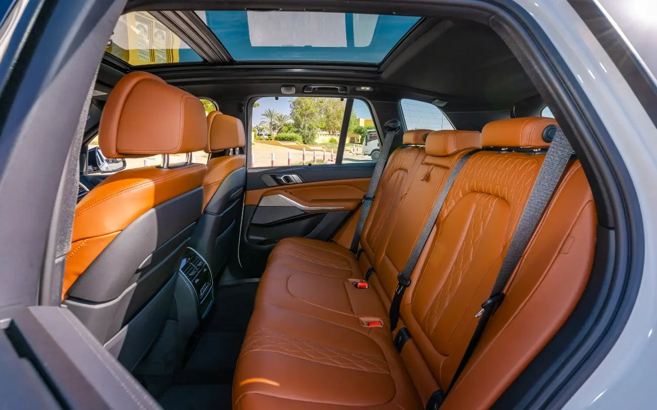 BMW X5 parked by Dubai's iconic landmarks, ready for an unforgettable rental journey.