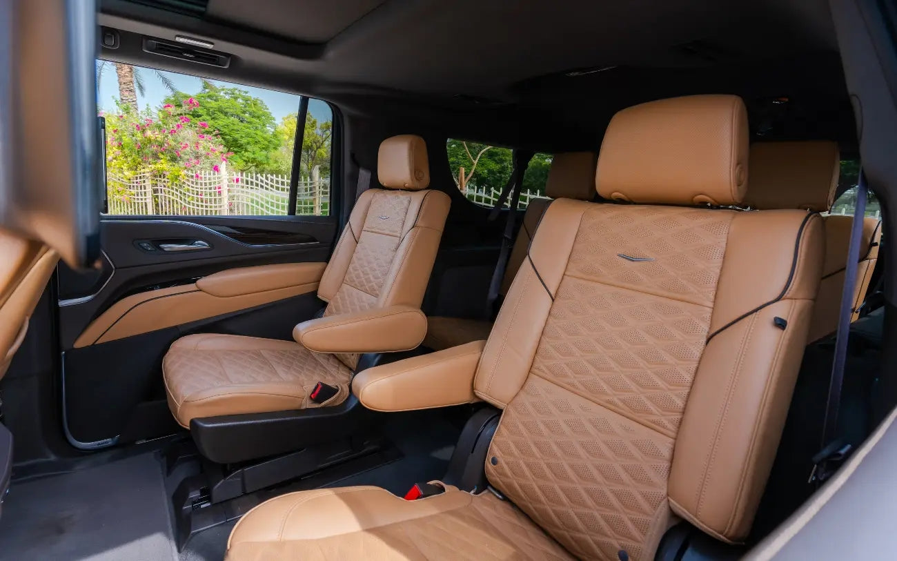 Cadillac Escalade XL cruising on Dubai roads, epitomizing luxury van rentals for discerning travelers.