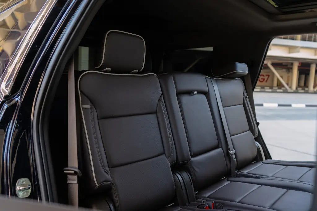 Side profile of a Chevrolet Tahoe under Dubai's skyline, rent this luxury SUV for an unforgettable journey.