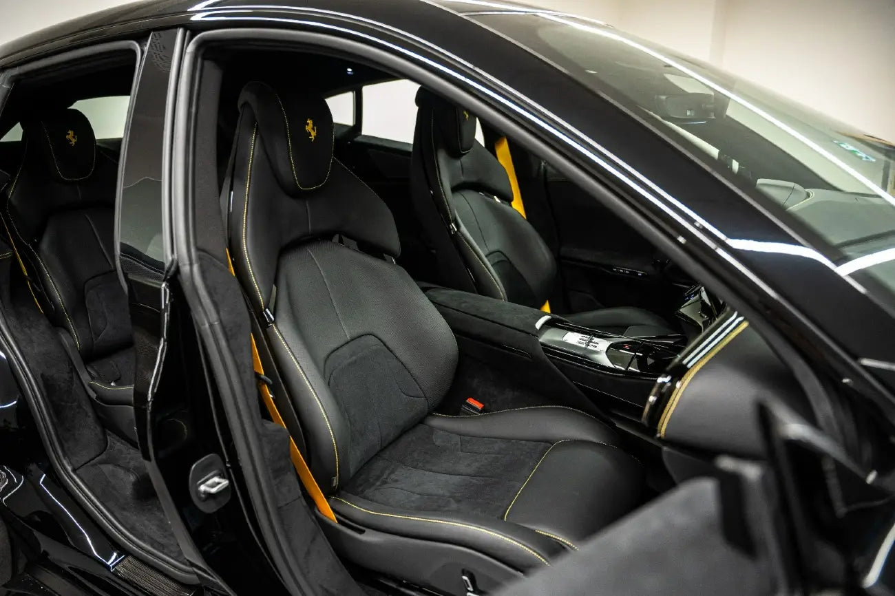 Dynamic action shot of the Ferrari Purosangue V12 driving through the desert near Dubai, available for luxury rental