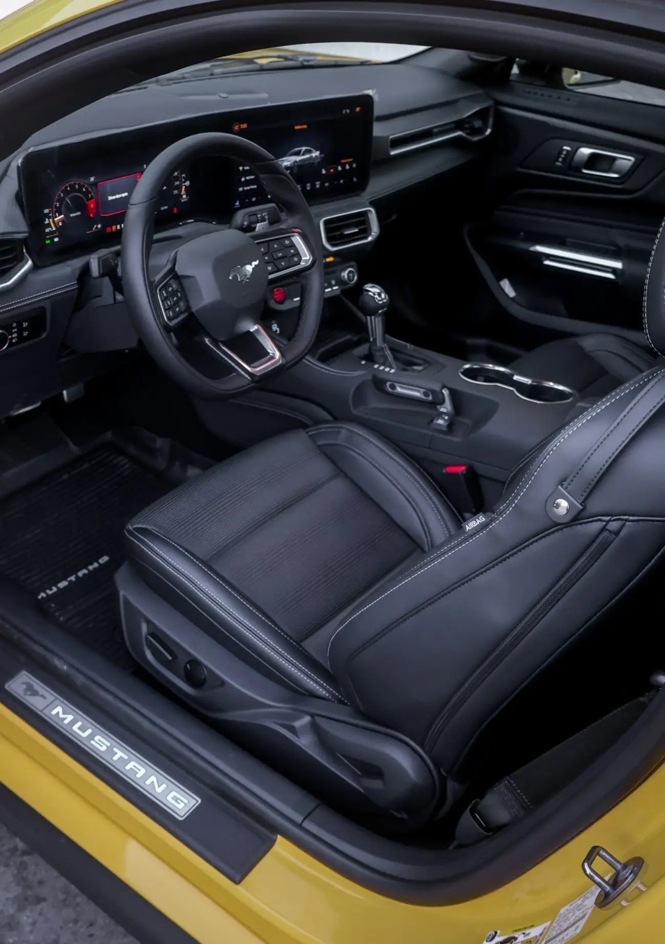 Night shot of a white Ford Mustang GT V8 with headlights on, cruising in Dubai, available for luxury rental.