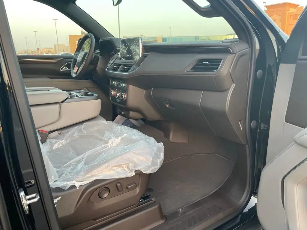 Dynamic aerial view of a GMC Yukon navigating Dubai's urban landscape, illustrating the blend of luxury and performance.