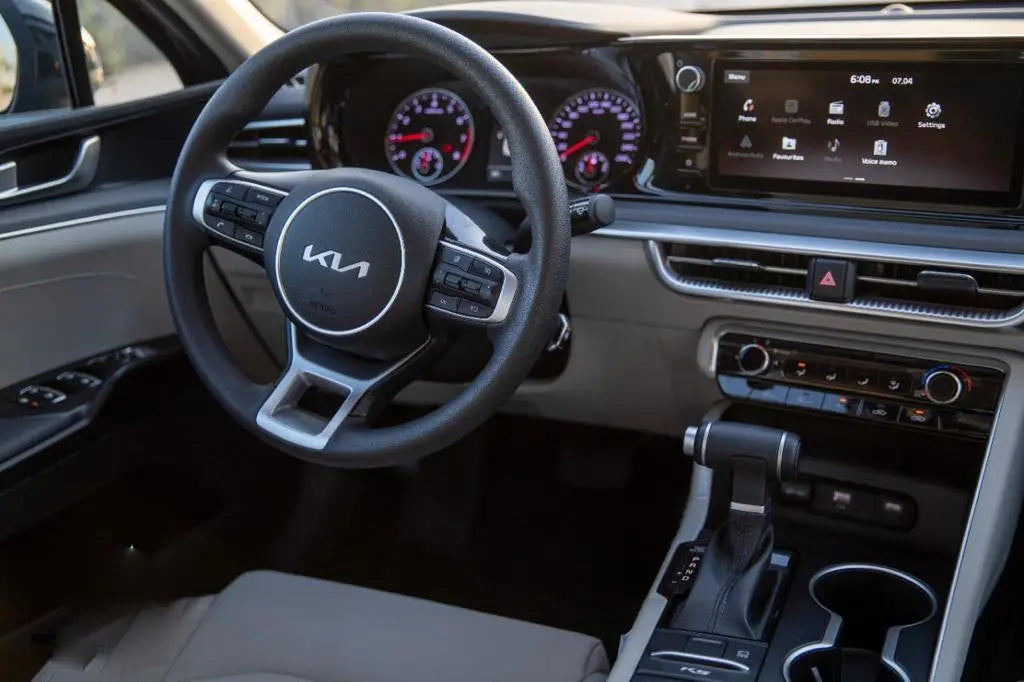 KIA K5 parked with Dubai skyline in the background, showcasing the ideal rental car for exploring the city in style.