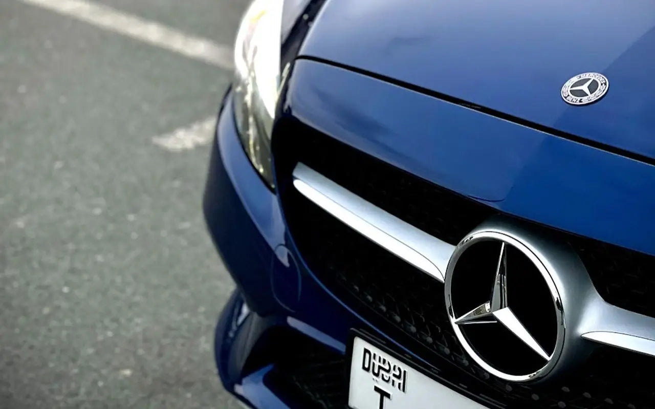 Mercedes C300 Convertible parked with Dubai skyline in the background, epitome of luxury rental.