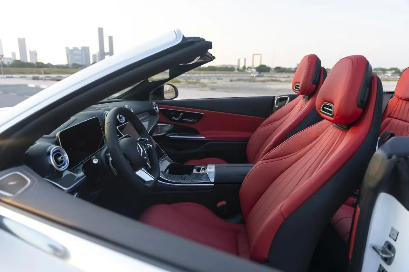 Night view of Mercedes CLE 200 convertible illuminated under Dubai lights, a top choice for luxury rentals.