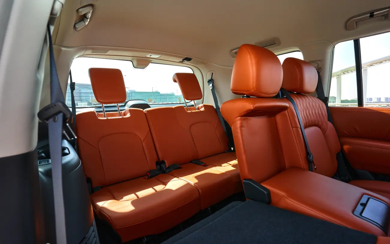 Dynamic angle of Nissan Patrol V6 driving through desert landscapes, perfect for adventurous rentals in Dubai.