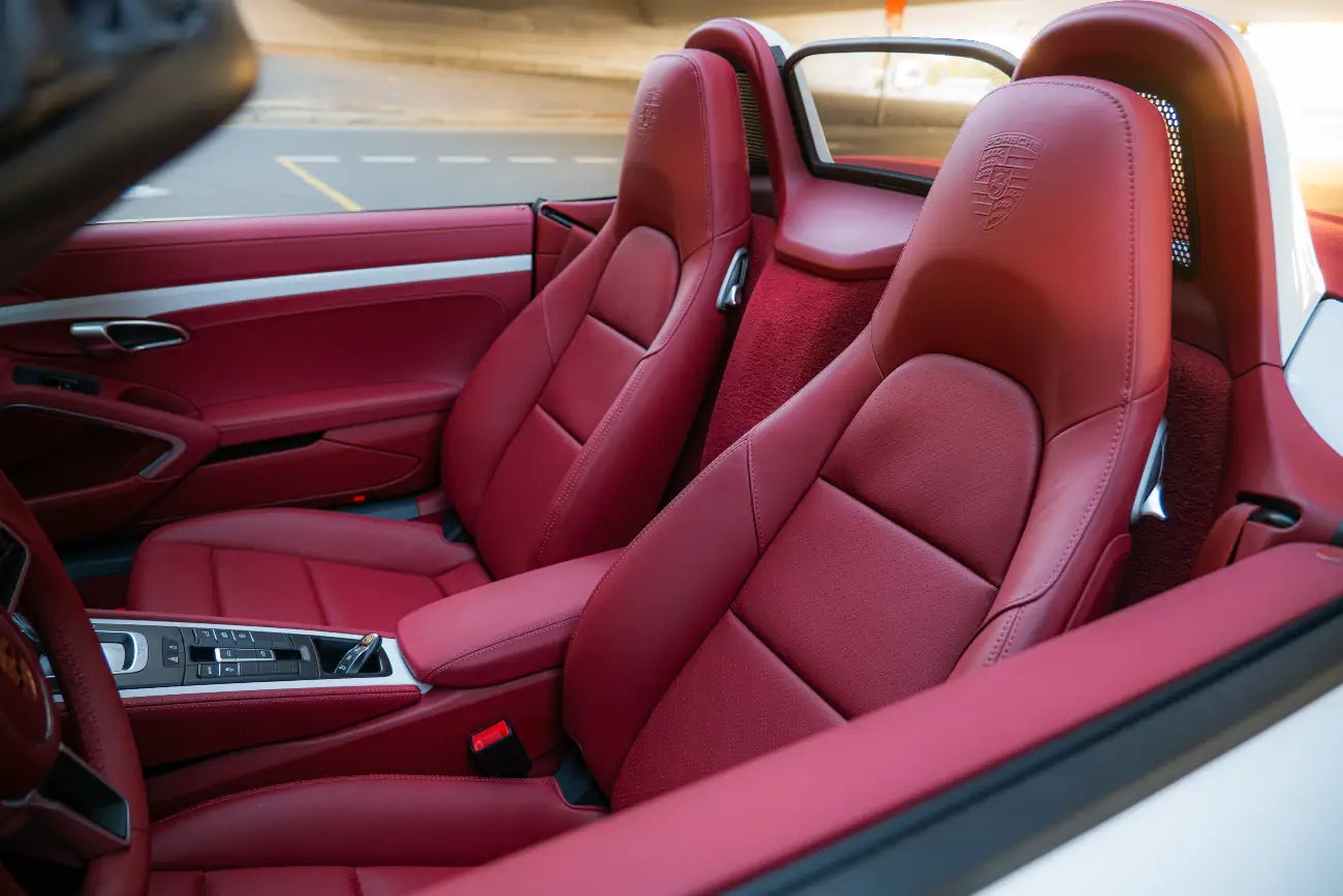 Night view of a lit Porsche 718 Boxster Convertible in Dubai, capturing the essence of luxury car rental.