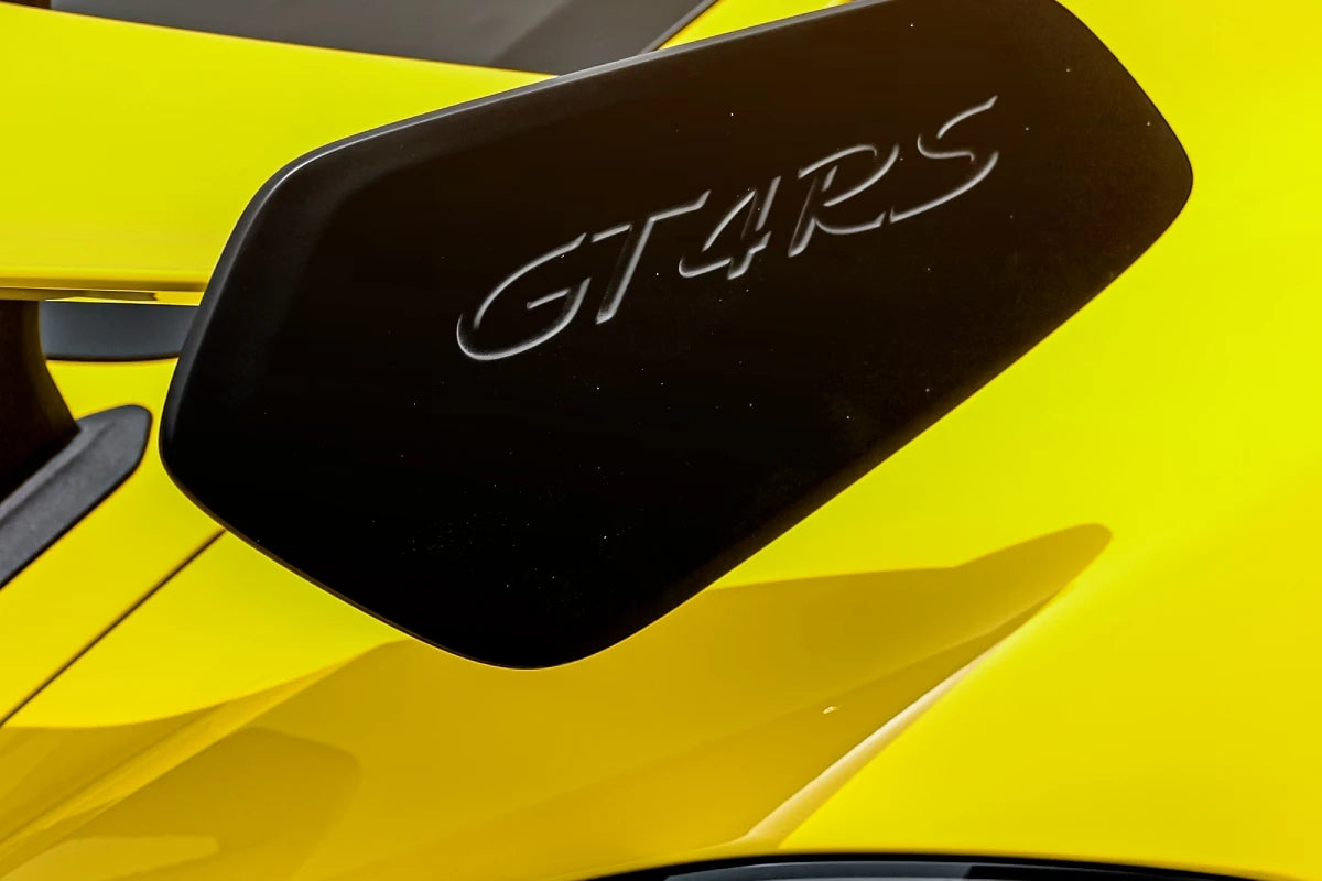 Dynamic Porsche 718 Cayman GT4 RS in full speed, the ultimate sports car rental experience in Dubai.