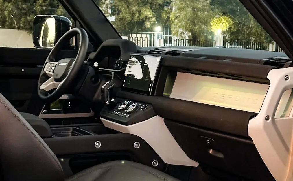 Range Rover Defender luxury SUV in motion on a Dubai highway, highlighting its power and elegance for enthusiasts to rent.