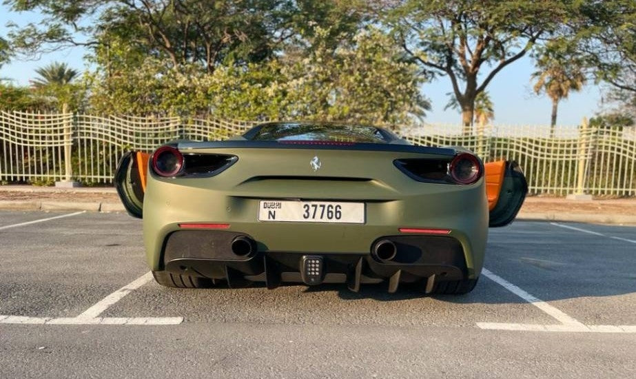 Ferrari 488 poised at sunset in Dubai, epitomizing luxury sports car rental elegance.