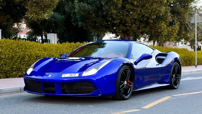 Luxury red Ferrari 488 sports car side view, ready for rent in Dubai, showcasing sleek design.