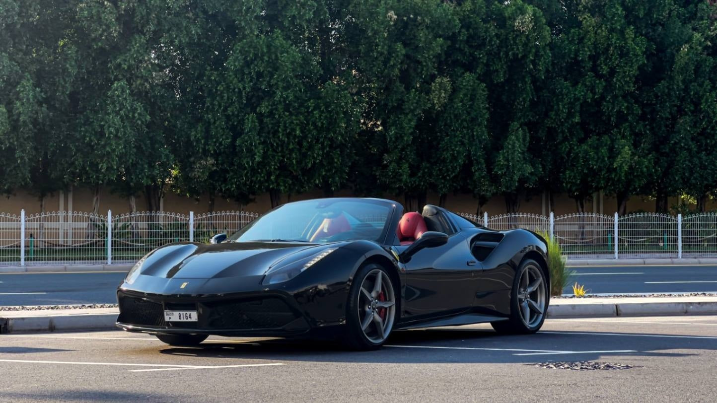 Luxury red Ferrari 488 Spyder rental, showcasing its sleek design and sporty profile, available in Dubai.