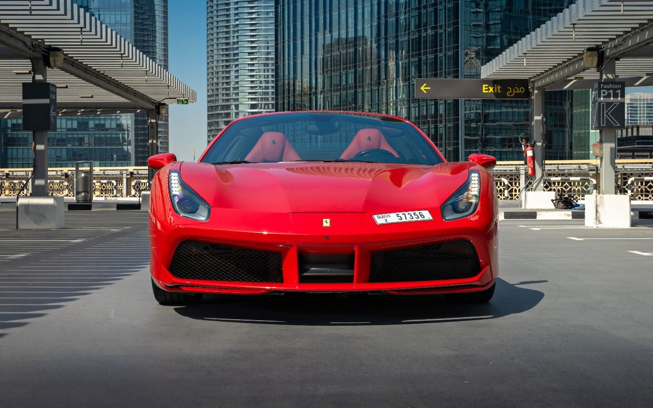 Front view of a Ferrari 488 Spyder rental in Dubai, highlighting the iconic prancing horse logo and aggressive headlights.