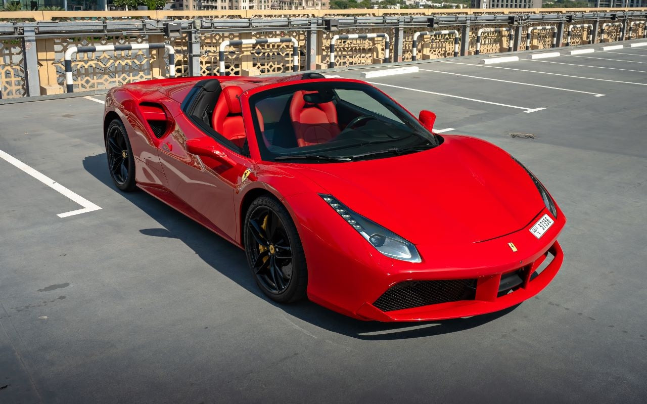 Interior shot of a Ferrari 488 Spyder for hire in Dubai, featuring luxurious leather seats and advanced dashboard controls.