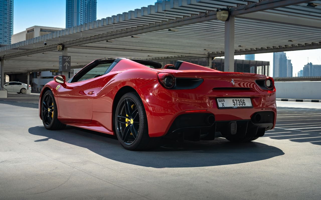 Close-up of the Ferrari 488 Spyder's alloy wheels and carbon fiber trim, available for luxury rental in Dubai.