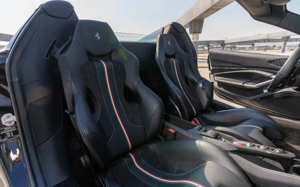 Action shot of a Ferrari F8 Tributo Spyder speeding along a Dubai highway, epitomizing luxury and performance in sports car rental.