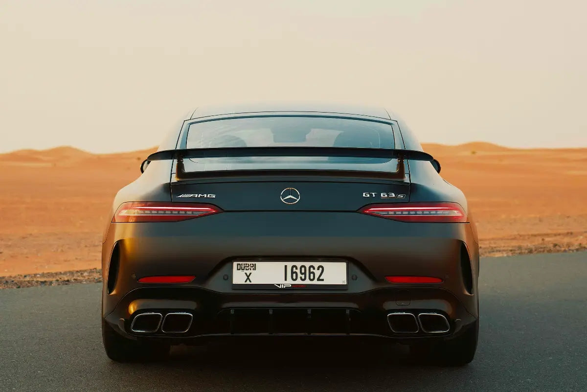 Dynamic rear view of the Mercedes Benz AMG GT 63s, showcasing the sporty exhaust and tail lights, available in Dubai.