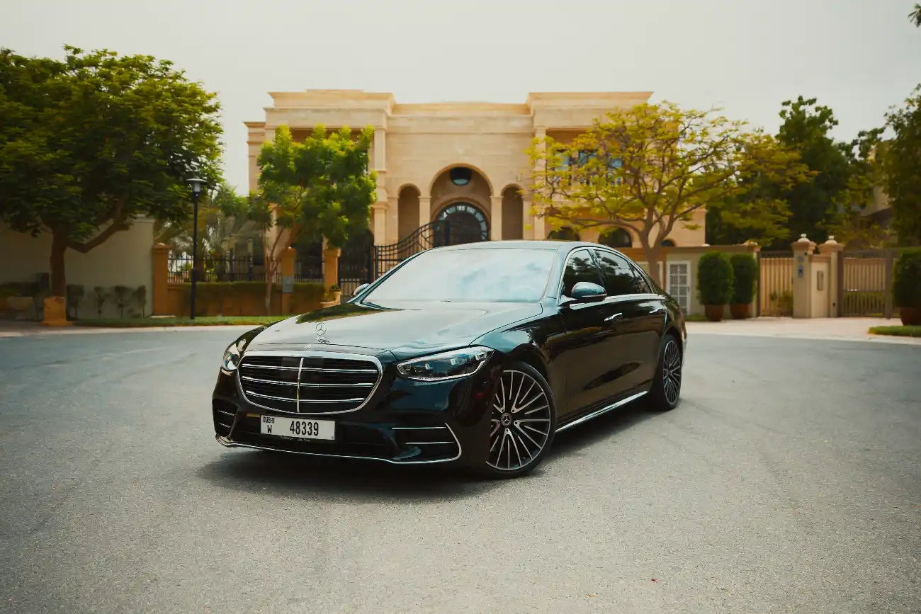 Elegant silver 2021 Mercedes-Benz S500 parked with Dubai skyline in the background - luxury sedan rental