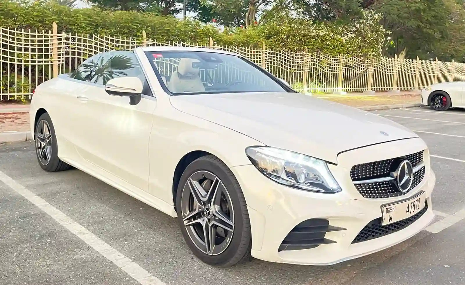 Elegant Mercedes C300 Convertible luxury rental parked with Dubai skyline in the background.