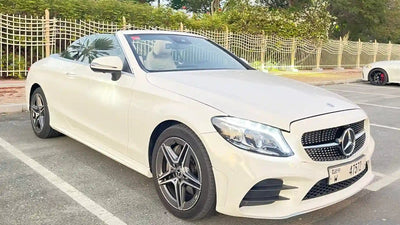 Elegant Mercedes C300 Convertible luxury rental parked with Dubai skyline in the background.