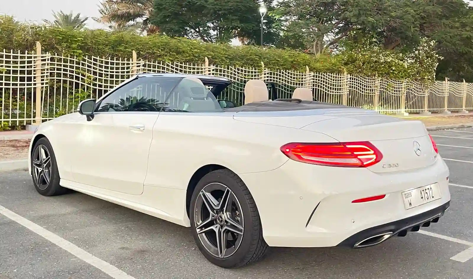 Rear angle of a Mercedes C300 Convertible rental, highlighting the convertible top and stylish tail lights.