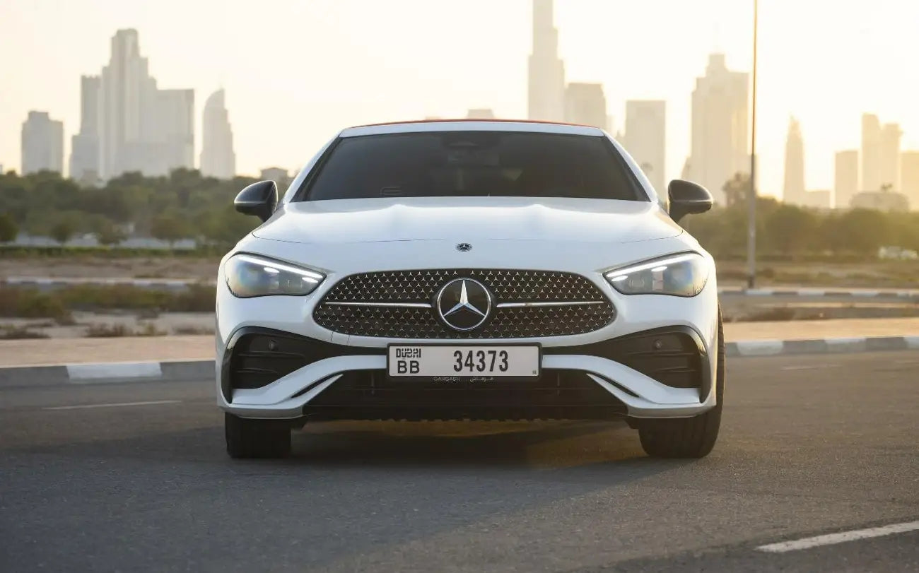 Mercedes CLE 200 convertible parked under Dubai skyline, epitome of luxury car rental elegance.