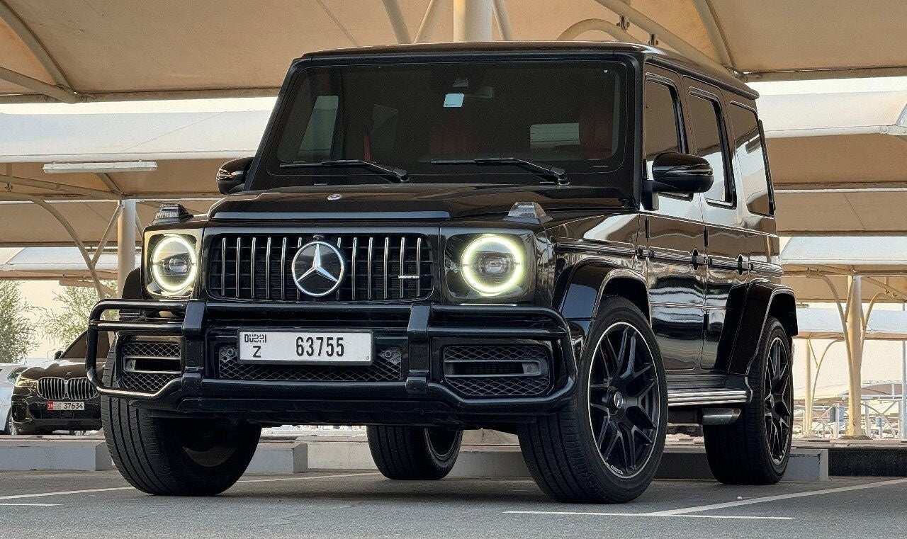 Luxury black Mercedes G63 AMG parked, ready for rent in Dubai - side view showcasing its elegant design.