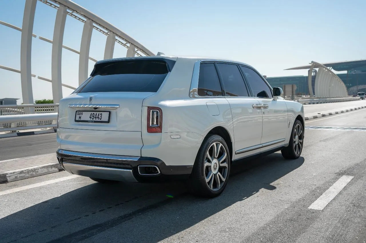 Rear angle of a Rolls Royce Cullinan, emphasizing the spacious cargo area and elegant tail lights, available for hire in Dubai.