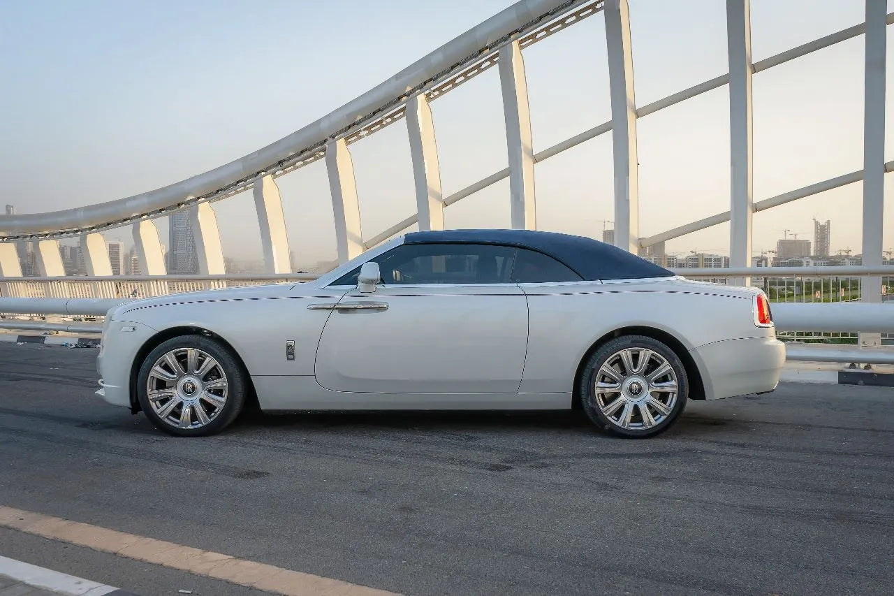 Elegant white Rolls Royce Dawn luxury convertible for rent in Dubai, showcasing its sleek design and sophistication.