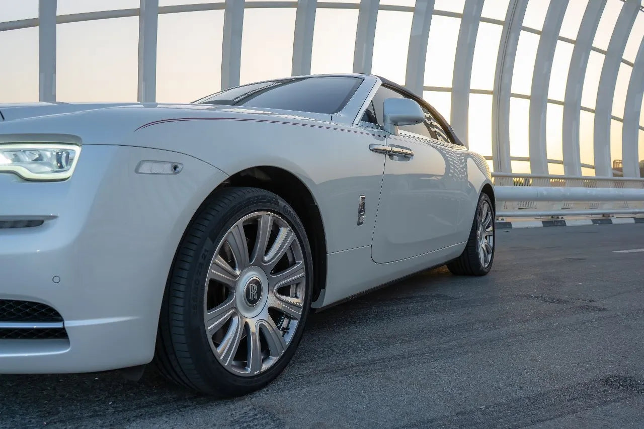 Luxurious interior of a Rolls Royce Dawn rental in Dubai, highlighting premium leather seats and advanced dashboard.