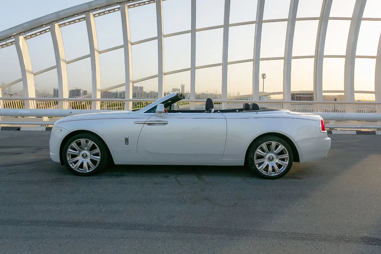 Side view of a pristine Rolls Royce Dawn convertible available for rent, embodying opulence on Dubai's roads.