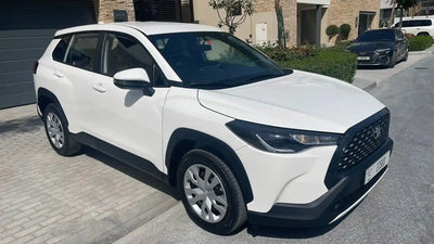 Brand new Toyota Corolla Cross economy rental car on Dubai streets, showcasing its sleek design.