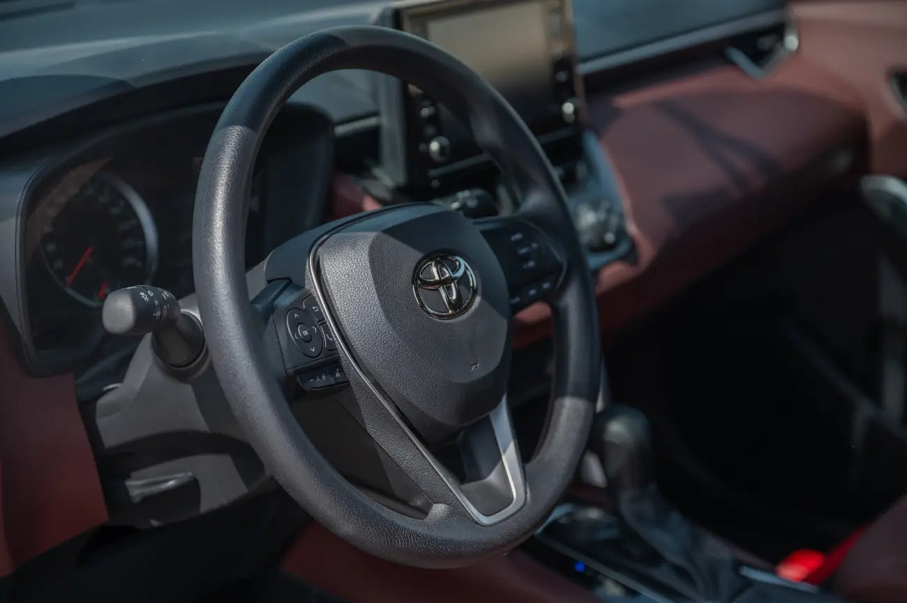 Close-up of the Toyota Corolla Cross's dashboard and steering wheel, illustrating the high-tech features in this Dubai rental SUV.