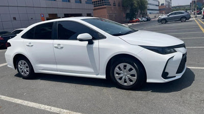 Front view of white Toyota Corolla economy car available for rent in Dubai, showcasing sleek design.