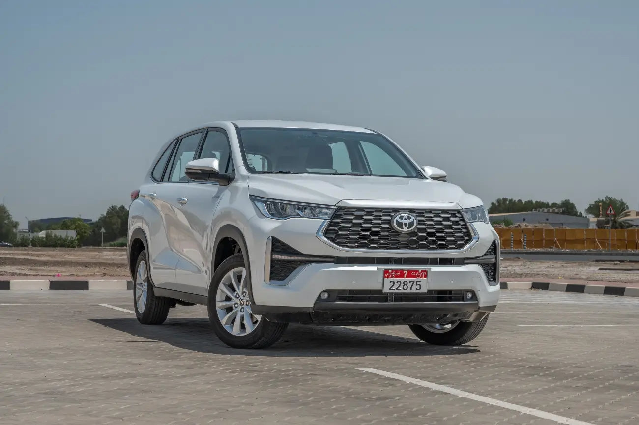 Elegant white Toyota Innova Hybrid luxury van parked, perfect for family rental in Dubai